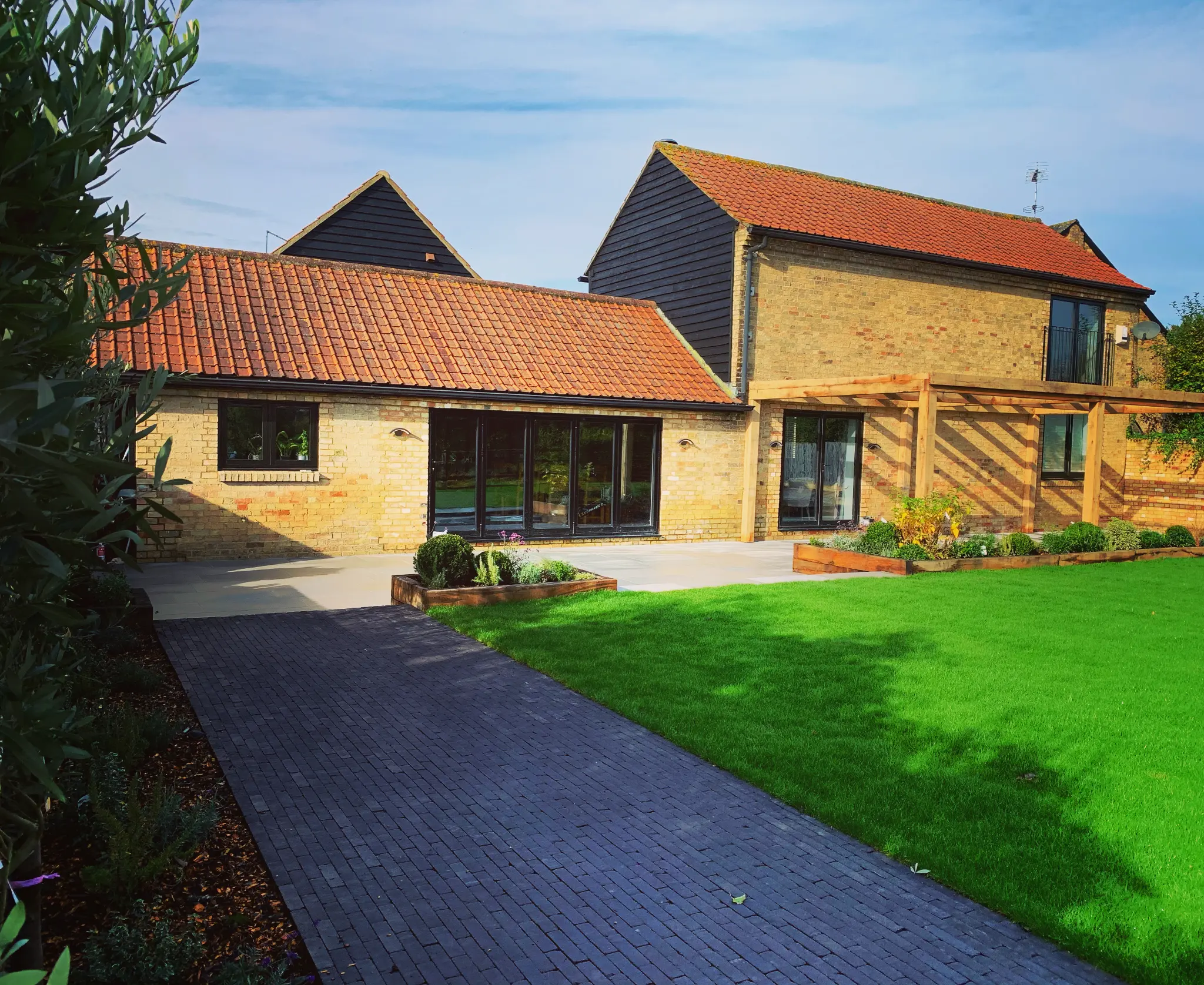 Completed Rowan Gardens lawn and terrace garden beside a brick house